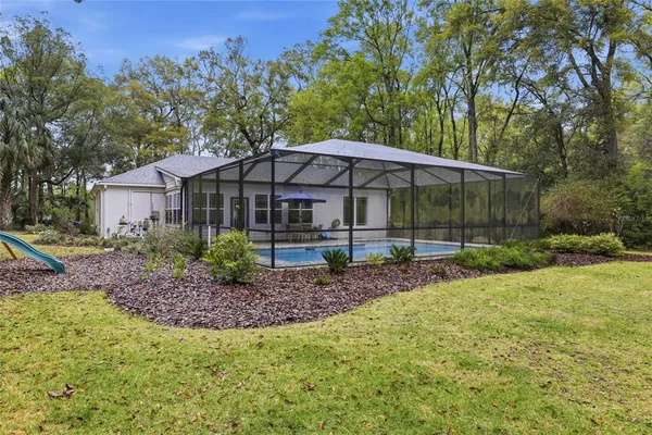 a view of a house with backyard and sitting area