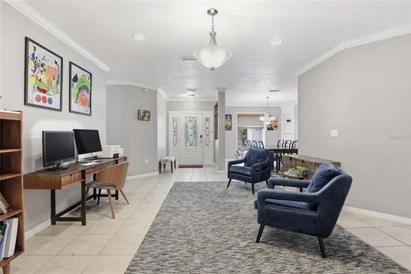a living room with furniture a piano and a chandelier