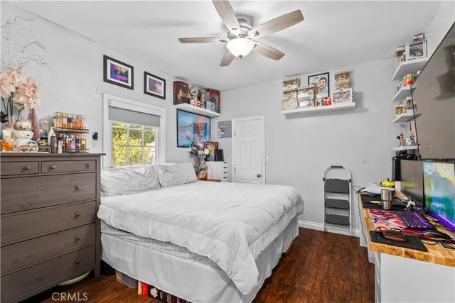 a bedroom with a bed and a bookshelf with wooden floor