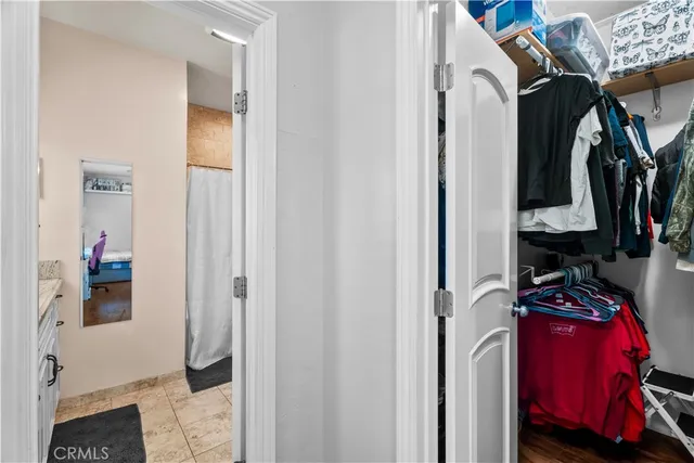 a view of walk in closet with clothes and shoes