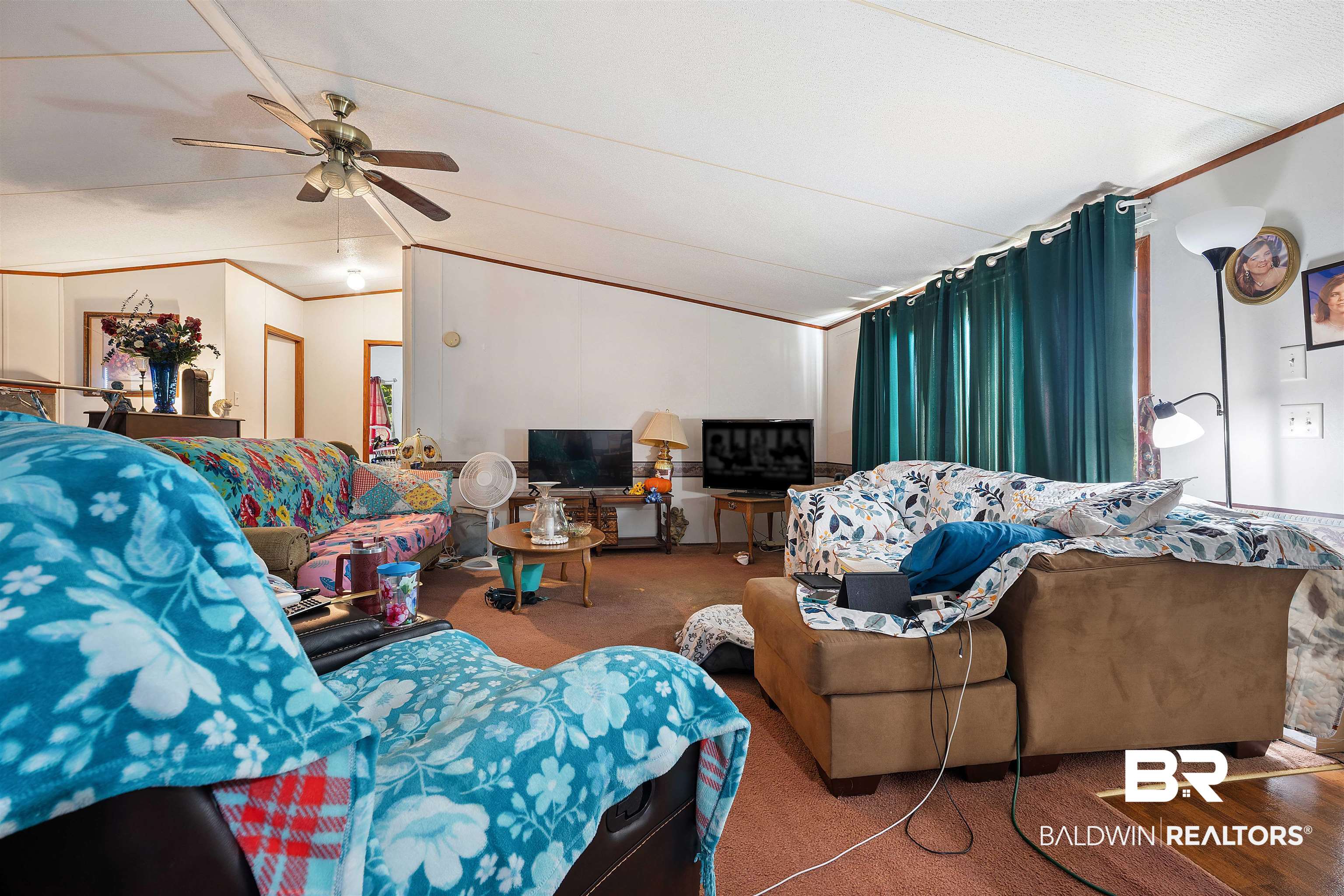 23700 Cumberland Road Robertsdale, AL 36567 - Photo 12 of 33 Carpeted living room featuring vaulted ceiling, crown molding, and ceiling fan