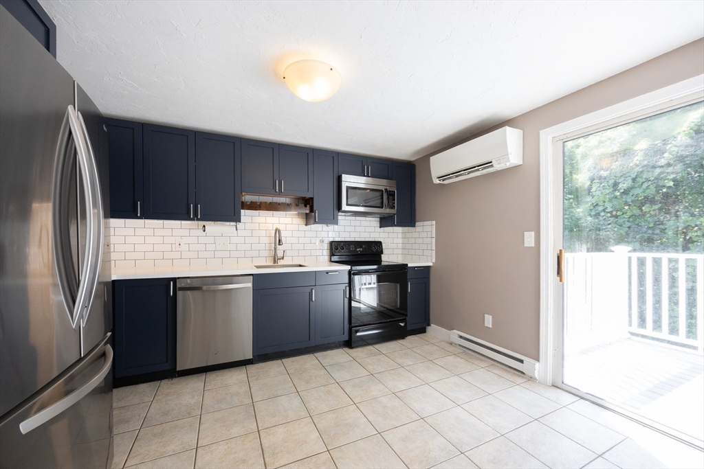 19 Cedar Square, Unit 19 Millis, MA 02054 - Photo 13 of 42 a kitchen with granite countertop a refrigerator and a stove top oven