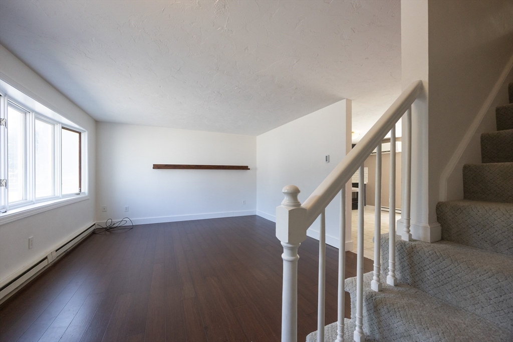19 Cedar Square, Unit 19 Millis, MA 02054 - Photo 8 of 42 a view of an empty room with wooden floor and fan