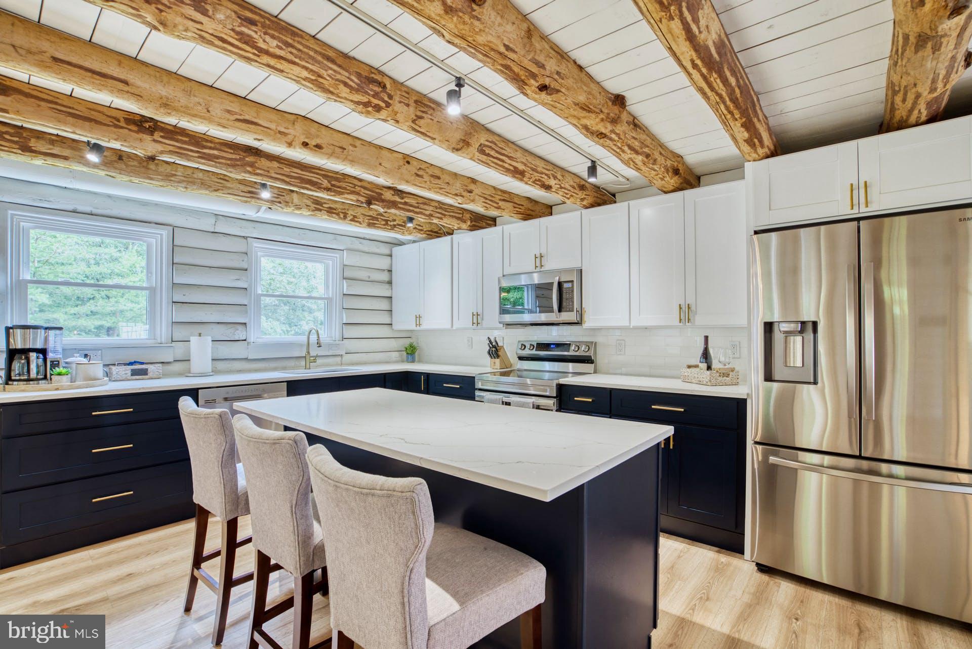 14422 Crawleys Dam Road Goldvein, VA 22720 - Photo 2 of 41 a kitchen with stainless steel appliances a table chairs and a refrigerator
