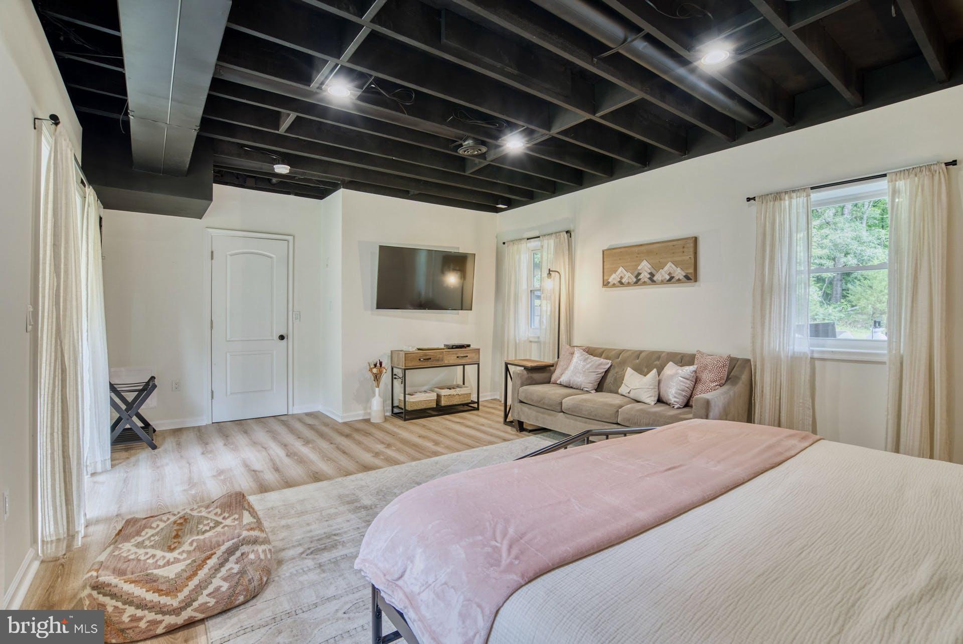 14422 Crawleys Dam Road Goldvein, VA 22720 - Photo 26 of 41 a spacious bedroom with a bed a couch and a window