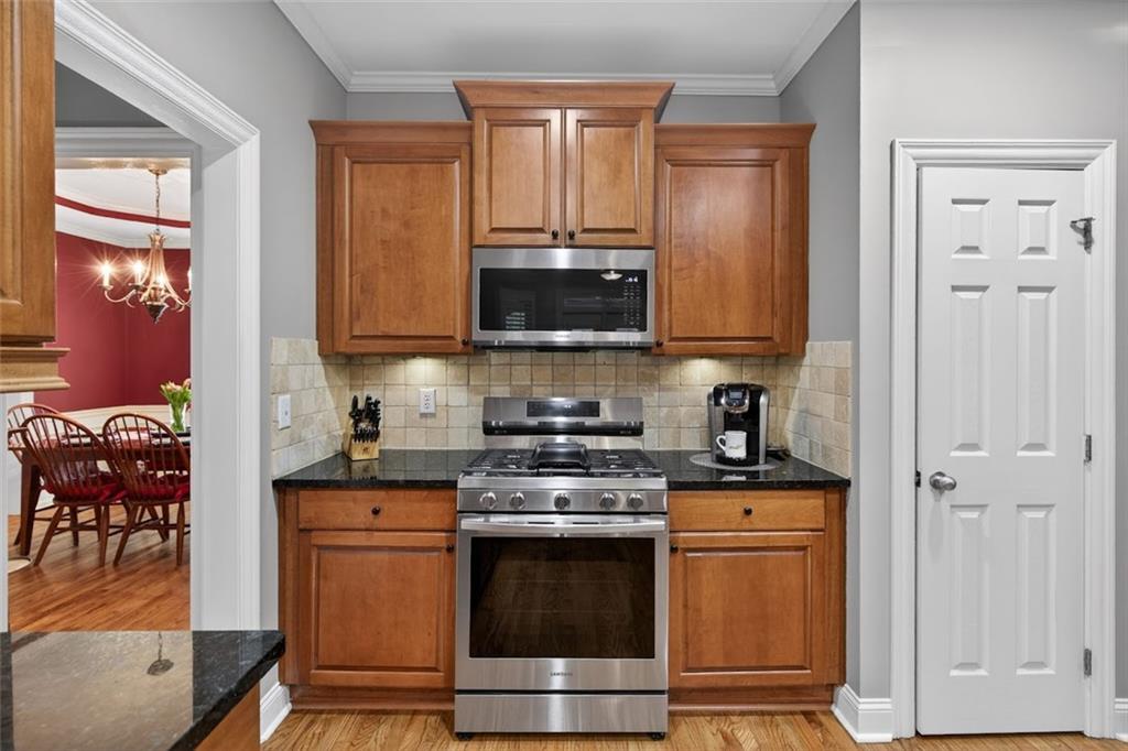 129 Dorchester Way Villa Rica, GA 30180 - Photo 12 of 65 a kitchen with stainless steel appliances granite countertop a stove a sink and a microwave