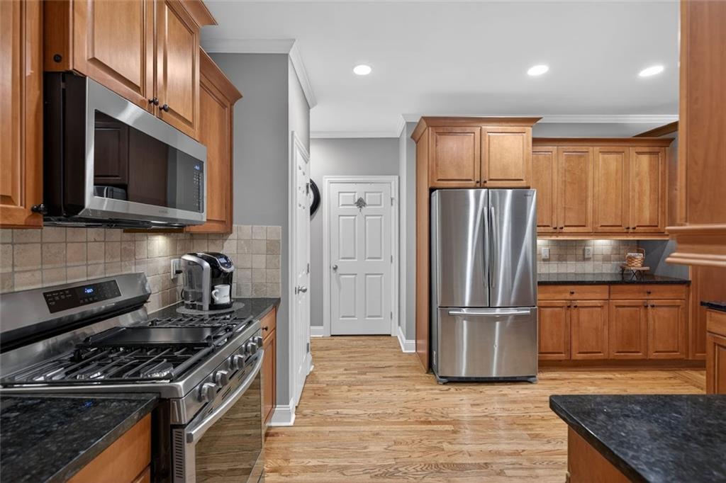 129 Dorchester Way Villa Rica, GA 30180 - Photo 8 of 65 a kitchen with stainless steel appliances granite countertop a refrigerator stove and microwave