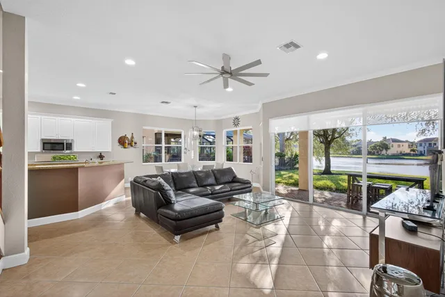 a living room with furniture and a large window with kitchen view