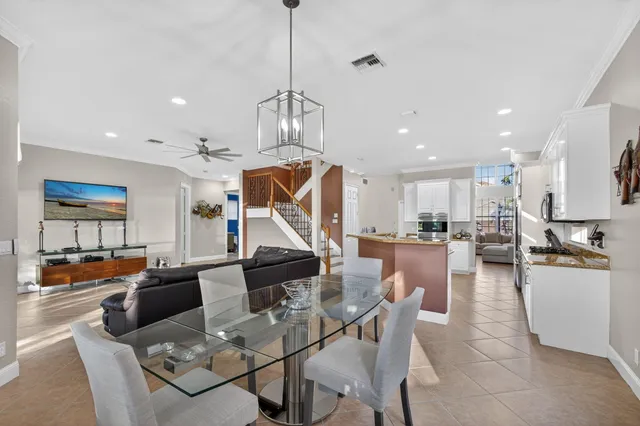 a living room with furniture kitchen view and a chandelier