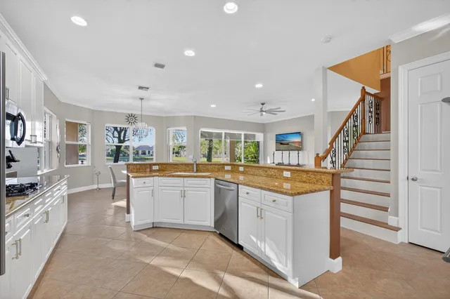 a kitchen with stainless steel appliances white cabinets and a window