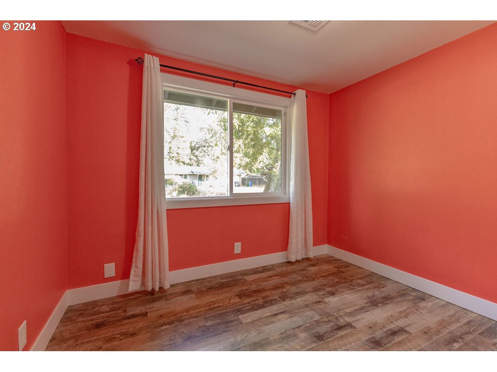 2102 Delta Street Eugene, OR 97404 - Photo 14 of 35 a view of an empty room with wooden floor and a window