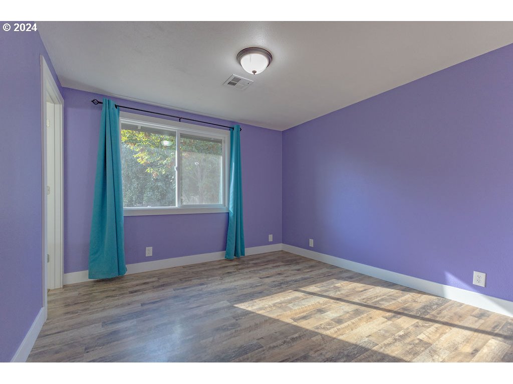 2102 Delta Street Eugene, OR 97404 - Photo 19 of 35 a view of an empty room with wooden floor and a window