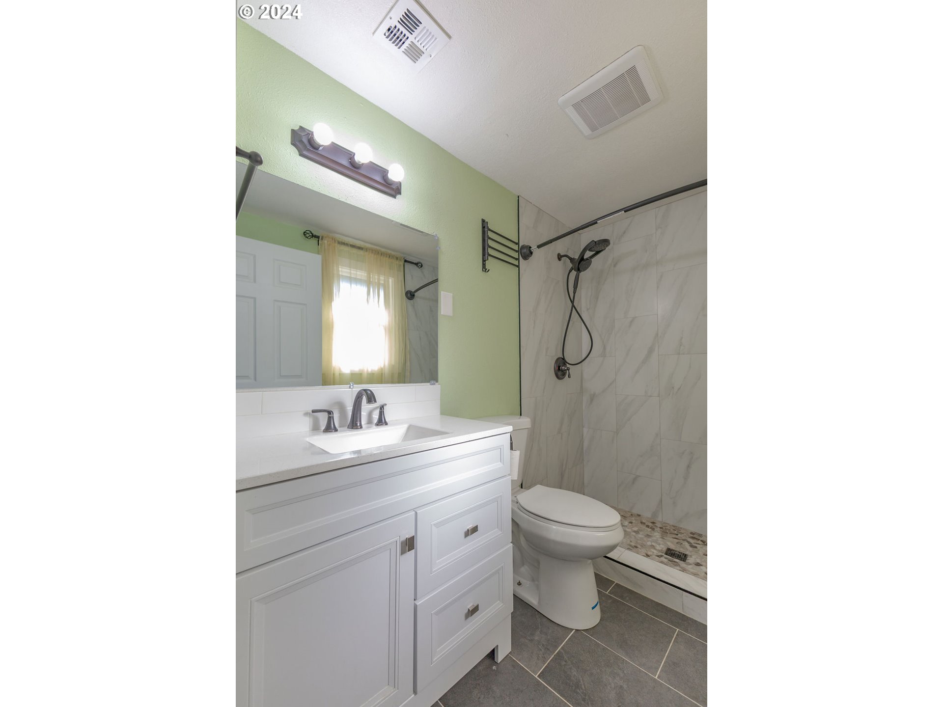 2102 Delta Street Eugene, OR 97404 - Photo 21 of 35 a bathroom with a double vanity sink toilet mirror and shower