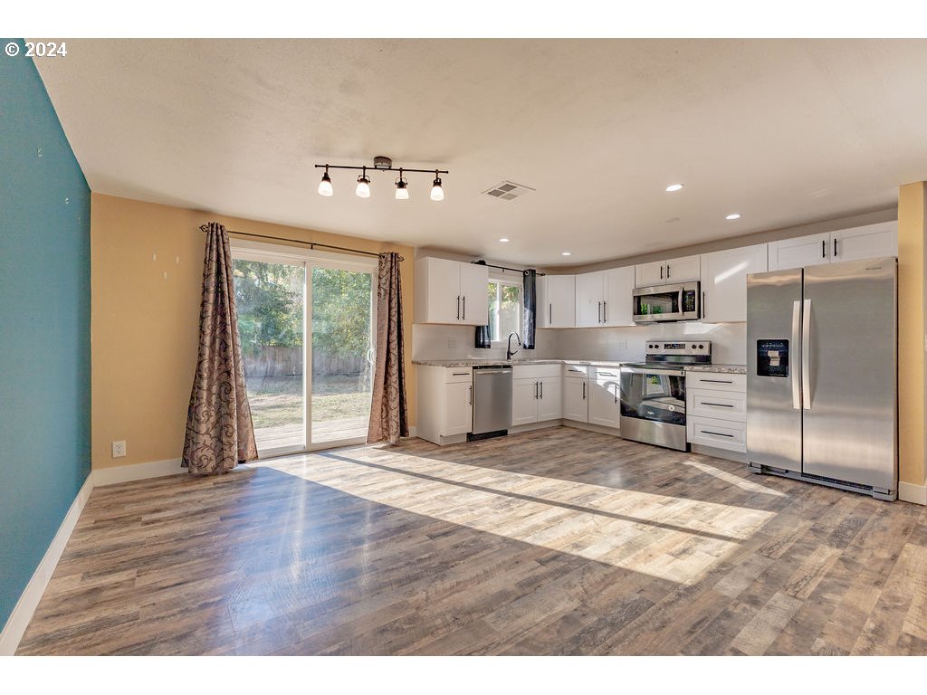 2102 Delta Street Eugene, OR 97404 - Photo 7 of 35 a view of a kitchen with wooden floor and stainless steel appliances