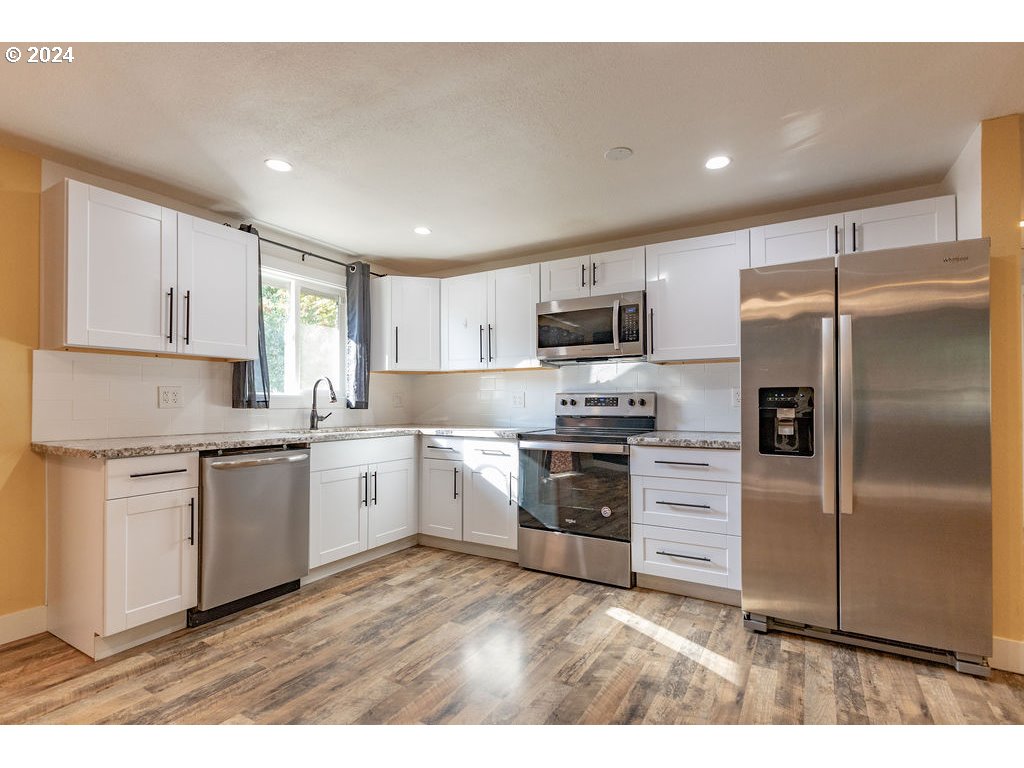 2102 Delta Street Eugene, OR 97404 - Photo 8 of 35 a kitchen with a refrigerator stove top oven and sink
