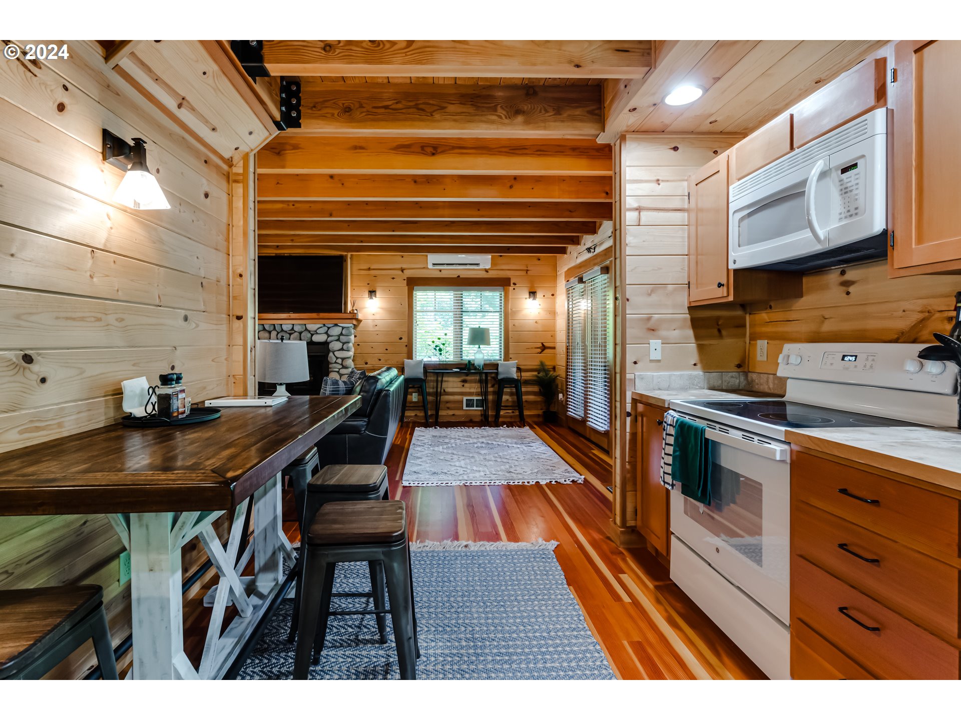 56483 McKenzie Highway Blue River, OR 97413 - Photo 11 of 38 a kitchen with stainless steel appliances kitchen island granite countertop a table chairs in it and wooden floor