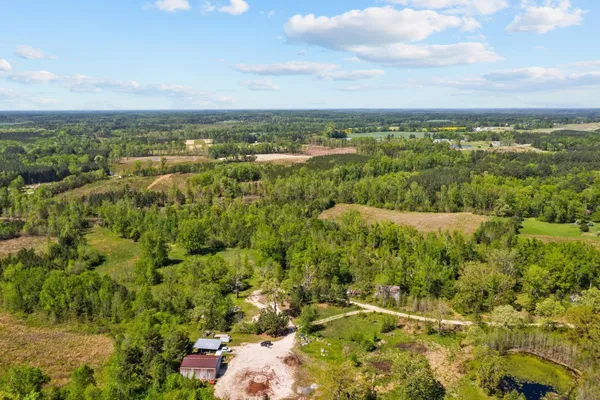 an aerial view of residential houses with outdoor space and trees