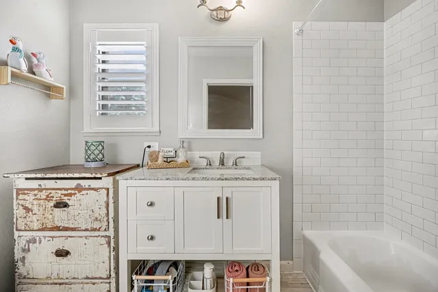 a bathroom with a granite countertop sink a toilet and bathtub