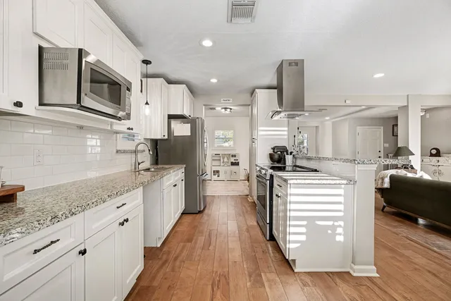 a kitchen with stainless steel appliances granite countertop a sink stove and refrigerator