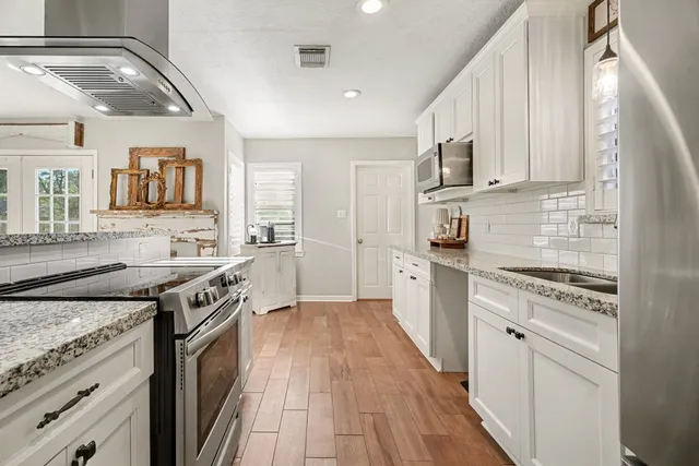 a large kitchen with stainless steel appliances kitchen island granite countertop a large counter top and stove