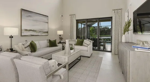 a kitchen with kitchen island a clock and a view of living room
