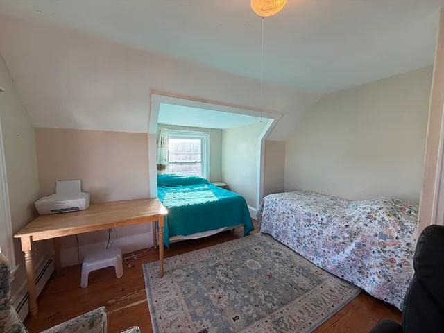 a bedroom with a bed and two windows