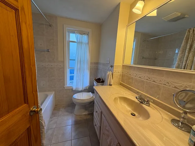 a bathroom with a sink a toilet a mirror and shower