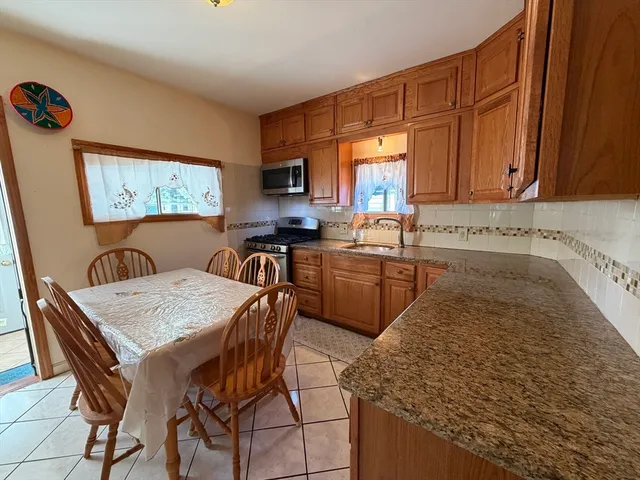 a kitchen with a sink a stove and chairs