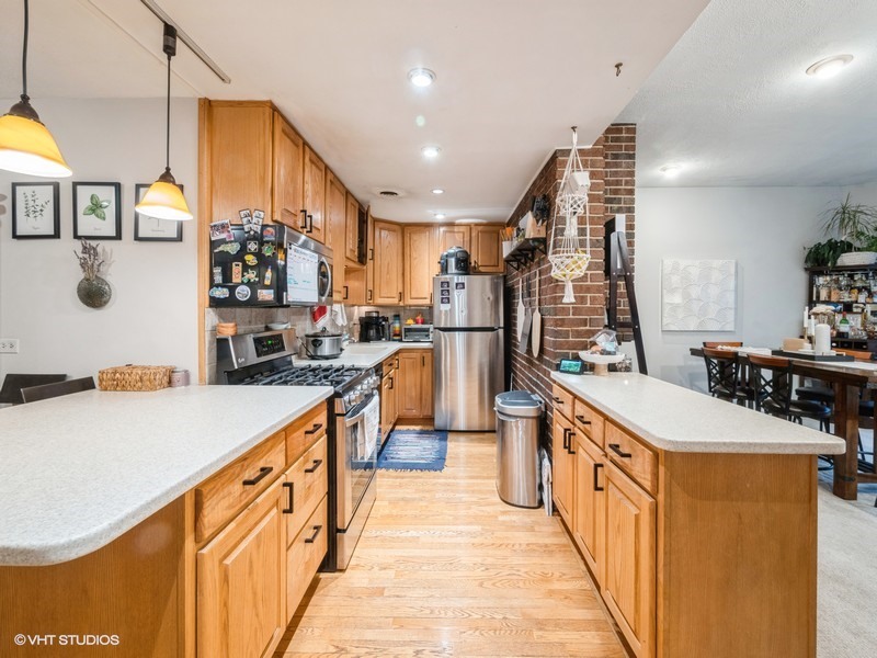 1038 West Byron Street, Unit 2E Chicago, IL 60613 - Photo 6 of 11 a kitchen with stainless steel appliances a sink stove and refrigerator