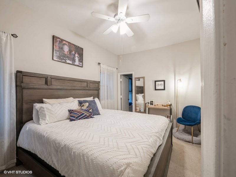 1038 West Byron Street, Unit 2E Chicago, IL 60613 - Photo 10 of 11 a bedroom with a bed and a chandelier