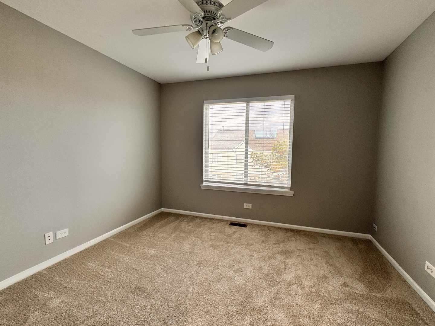1617 Spaulding Road Bartlett, IL 60103 - Photo 8 of 9 an empty room with a chandelier fan and windows