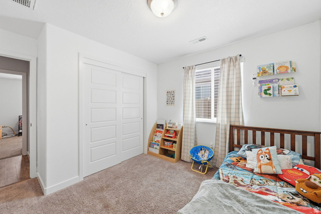 1175 Silver Hollow Road Syracuse, UT 84075 - Photo 21 of 34 Bright room featuring a window with blinds, a ceiling-mounted light fixture, and plush carpeting