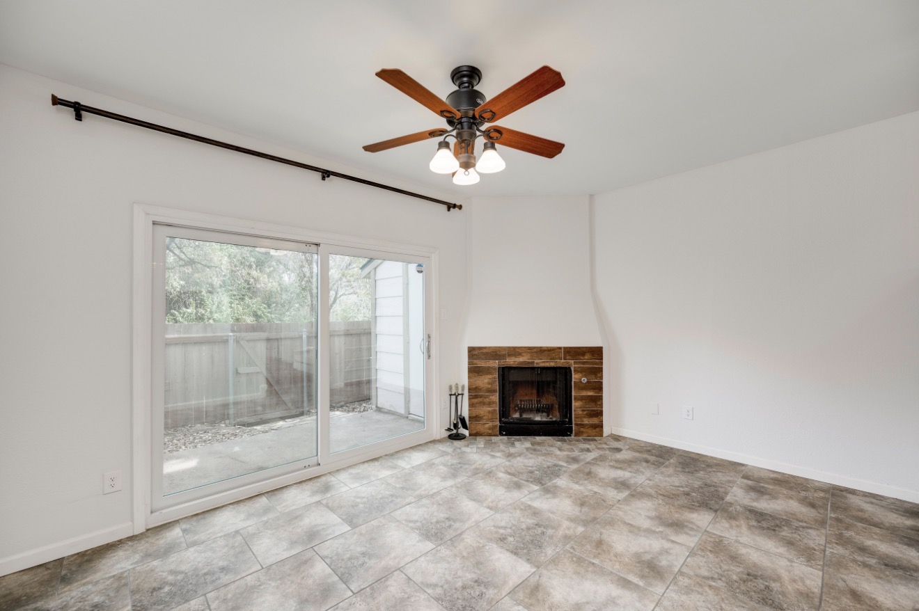11821 Bittern Hollow, Unit 34 Austin, TX 78758 - Photo 12 of 29 Unfurnished living room with ceiling fan and a fireplace