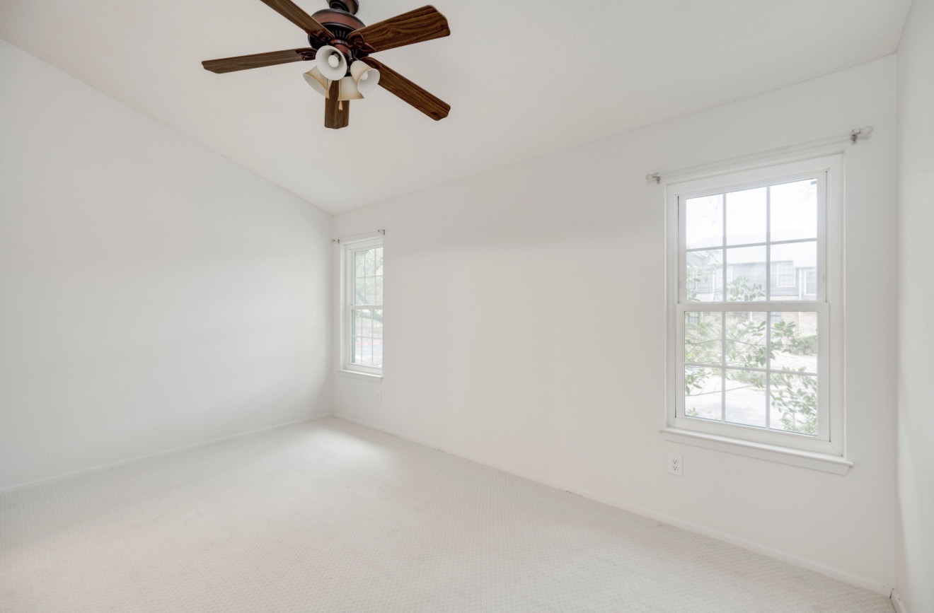 11821 Bittern Hollow, Unit 34 Austin, TX 78758 - Photo 18 of 29 Carpeted spare room featuring a ceiling fan and vaulted ceiling