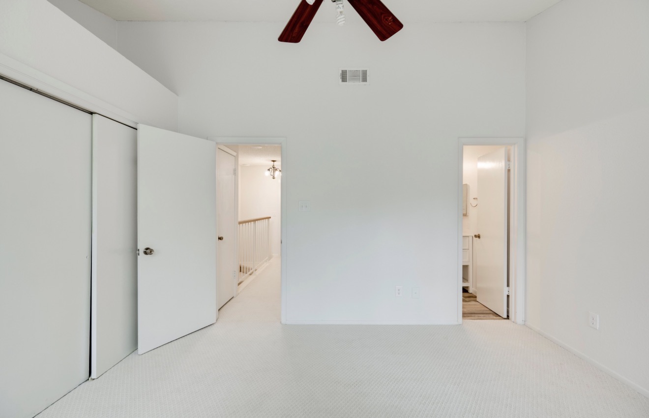 11821 Bittern Hollow, Unit 34 Austin, TX 78758 - Photo 24 of 29 Unfurnished bedroom with a high ceiling, a closet, a ceiling fan, and carpet