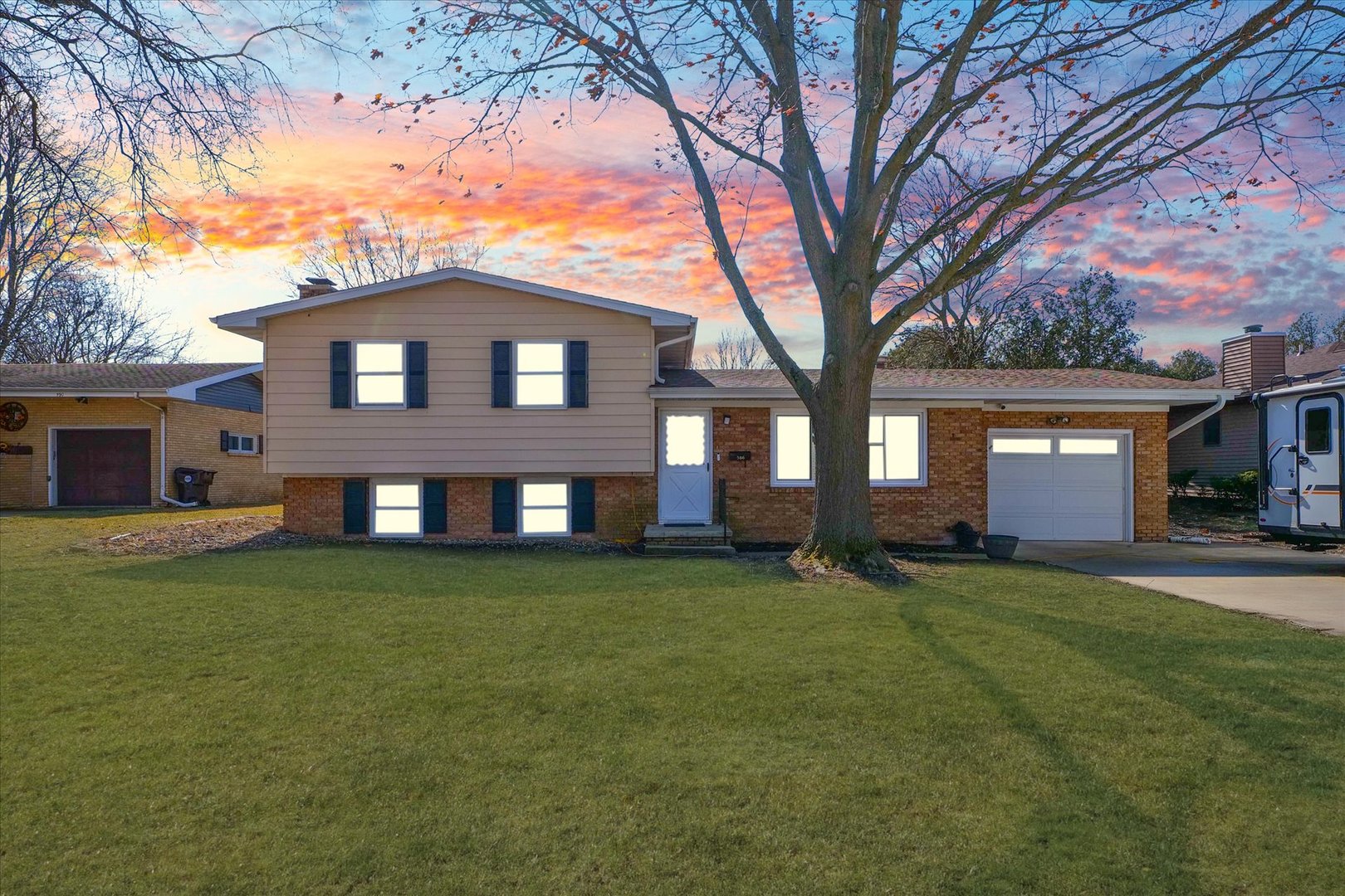 586 Hazelcrest Place Rantoul, IL 61866 - Photo 6 of 47 a view of a yard in front of a brick house with a large tree