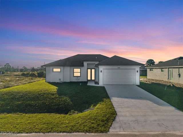 a front view of a house with a yard and garage