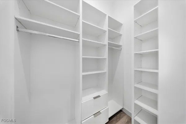a view of walk in closet with empty racks