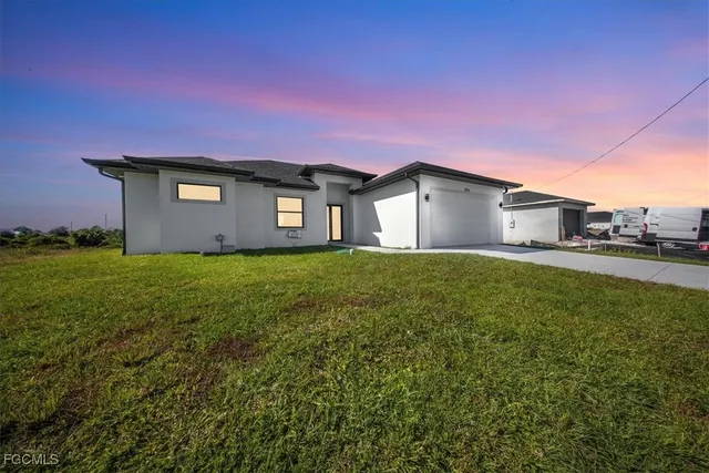 a front view of a house with a big yard and large tree