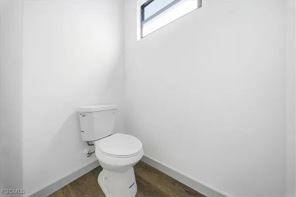 a white toilet sitting next to a white wall