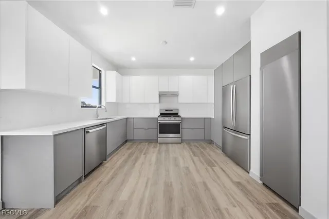 a kitchen with a refrigerator a sink and cabinets