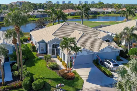 an aerial view of a house with a yard and lake view