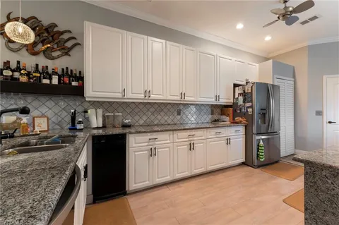 a kitchen with granite countertop a sink cabinets and stainless steel appliances