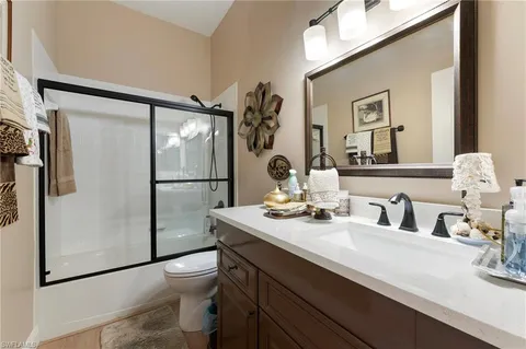 a bathroom with a sink mirror toilet and shower