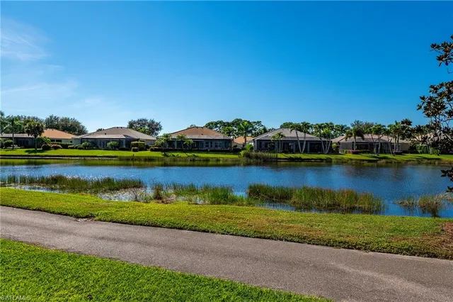 an aerial view of a residential houses with outdoor space and lake view