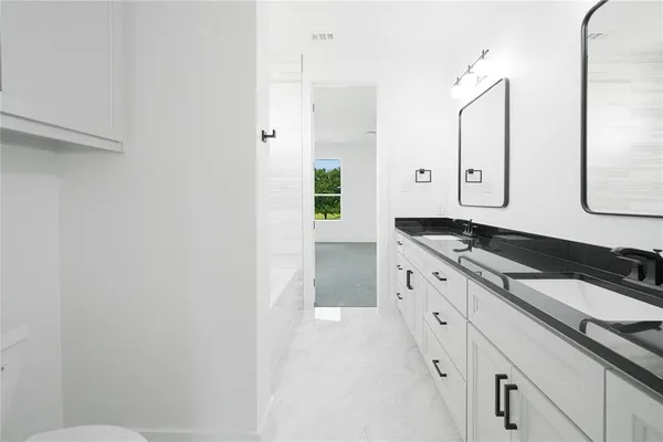 a bathroom with a tub sink and mirror
