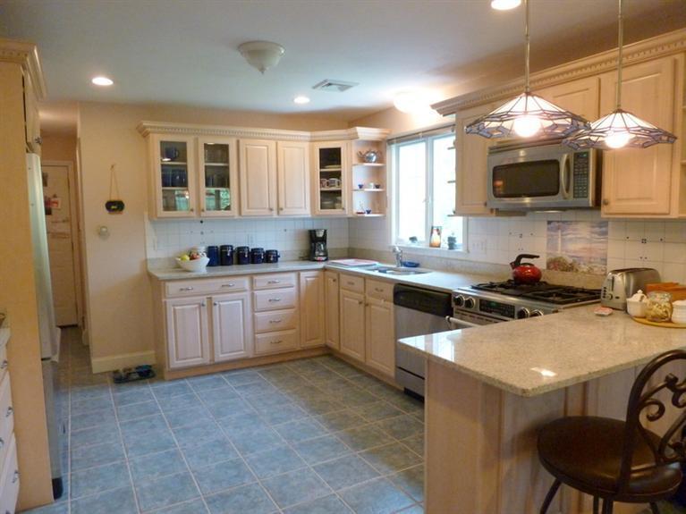 6 Penelope Road Bourne, MA 02532 - Photo 6 of 13 a kitchen with a sink a stove a microwave cabinets and a dining table