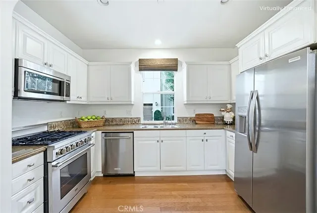 a kitchen with granite countertop a refrigerator stove top oven and sink