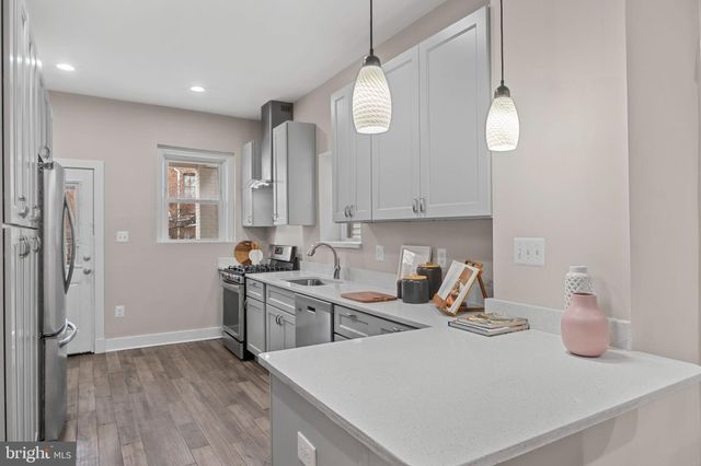 a kitchen with stainless steel appliances a stove sink and cabinets