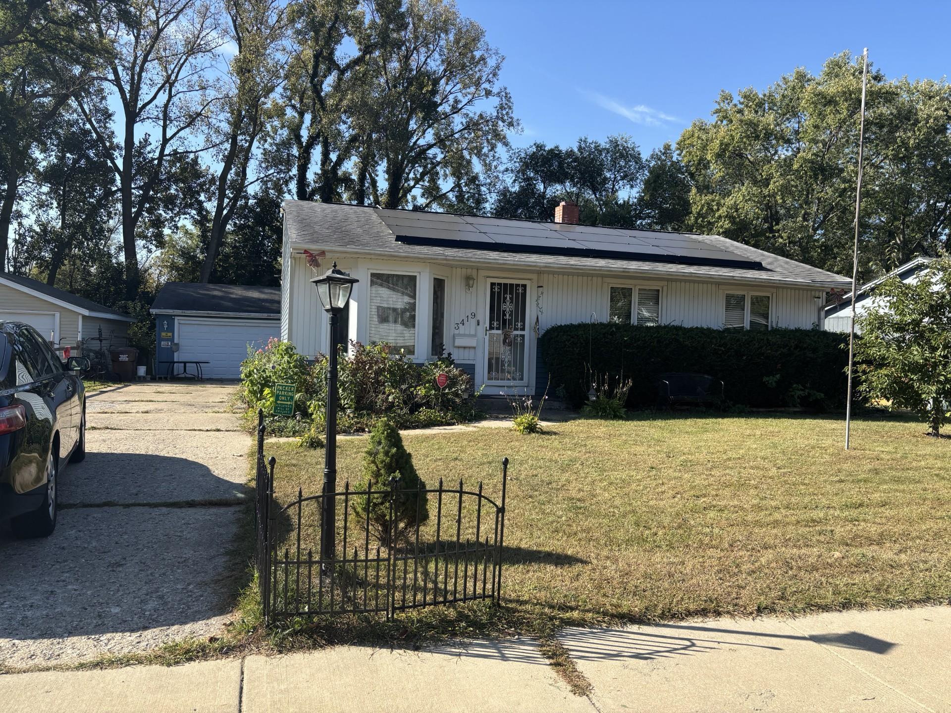 a front view of house with yard and trees in the background
